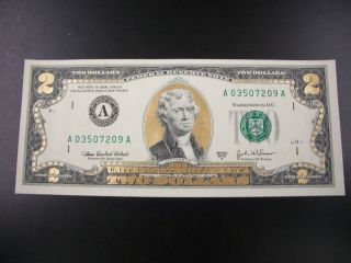one colorized gold uncirulated two dollar bill 