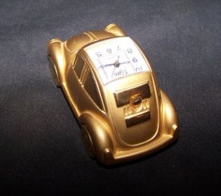 This is a cute beetle bug car clock by elgin. It is gold in color. It 